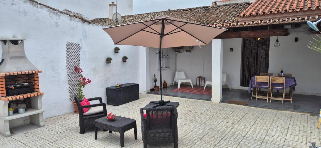 a patio with an umbrella and chairs and a table at Casa da Fonte / Fountain House in Monsaraz