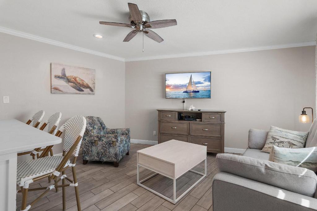a living room with a ceiling fan and a table at Capri by the Gulf 122 in Destin