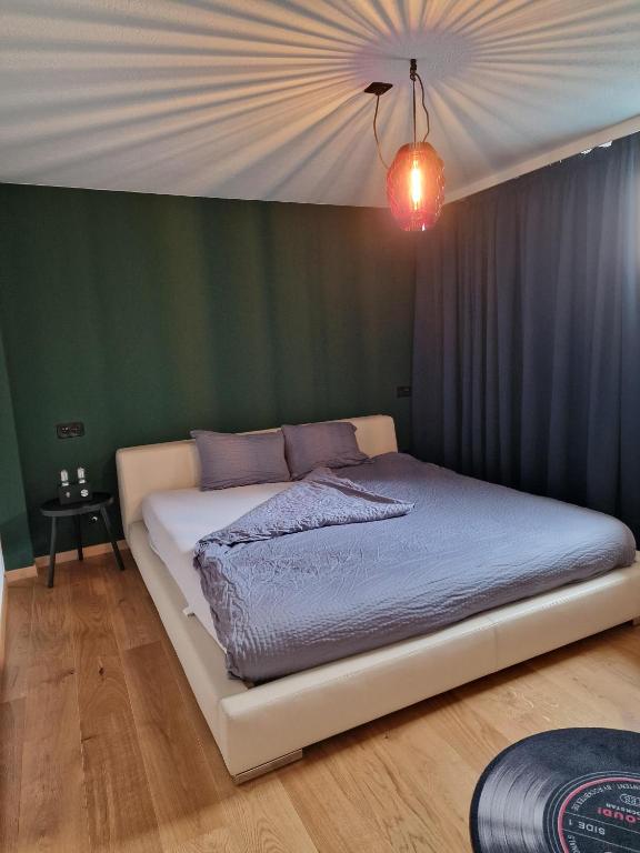 a bed in a room with a green wall at Kugelgasse Apartments - Smart Living by Klang und Kleid in St. Gallen
