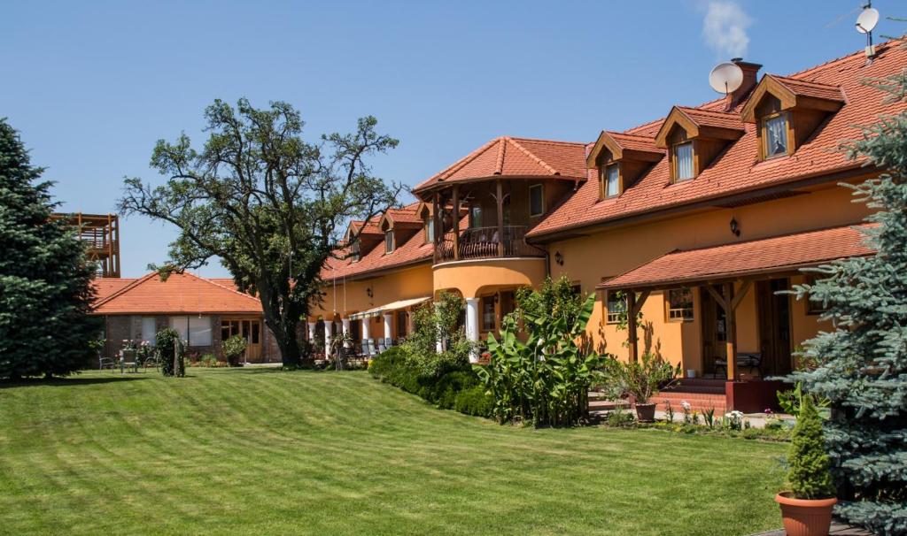 a large house with a yard in front of it at Hárs Fogadó 