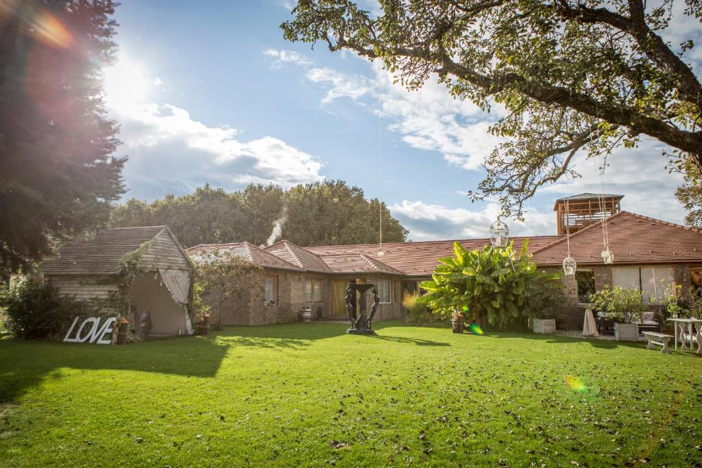 a house with a yard with green grass at Hárs Fogadó in Ötvös