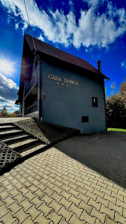 a building with a sign on the side of it at Cabana Donca in Bistra Mureşului