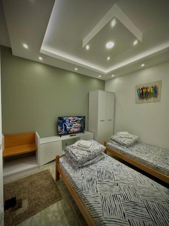 a room with two beds and a tv in it at Lux A2 in Jošanička Banja