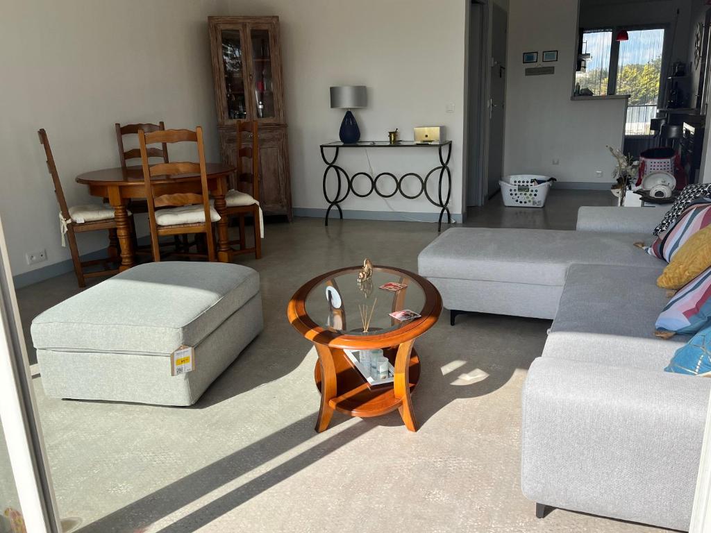 a living room with two couches and a table at Rêver en bord de mer in Saint-Michel-Chef-Chef
