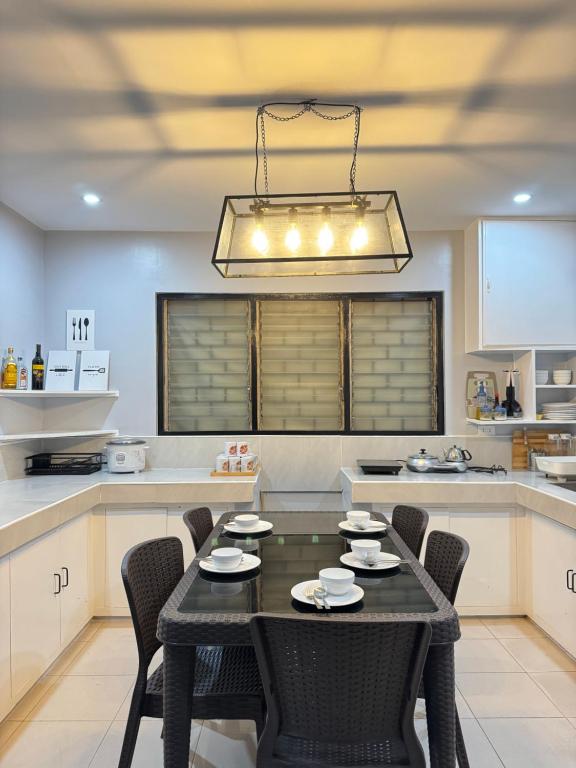 une cuisine avec une table et des chaises noires dans l'établissement Matthews Home Cebu-Casa Uno, à Cebu
