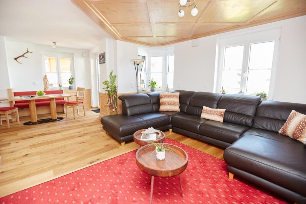 - un salon avec un canapé en cuir noir et une table dans l'établissement Oberstdorfer Bergwelt Herbers, à Oberstdorf