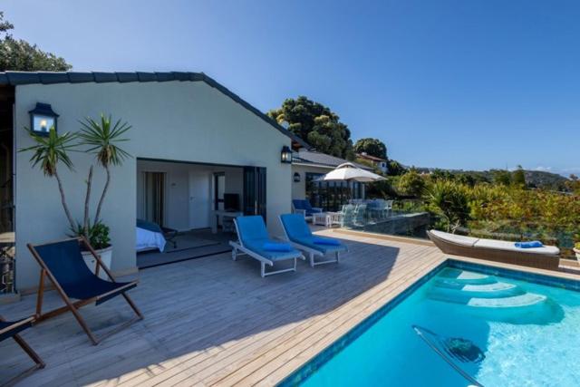 a patio with chairs and a swimming pool at 9 Pladda Drive in Plettenberg Bay