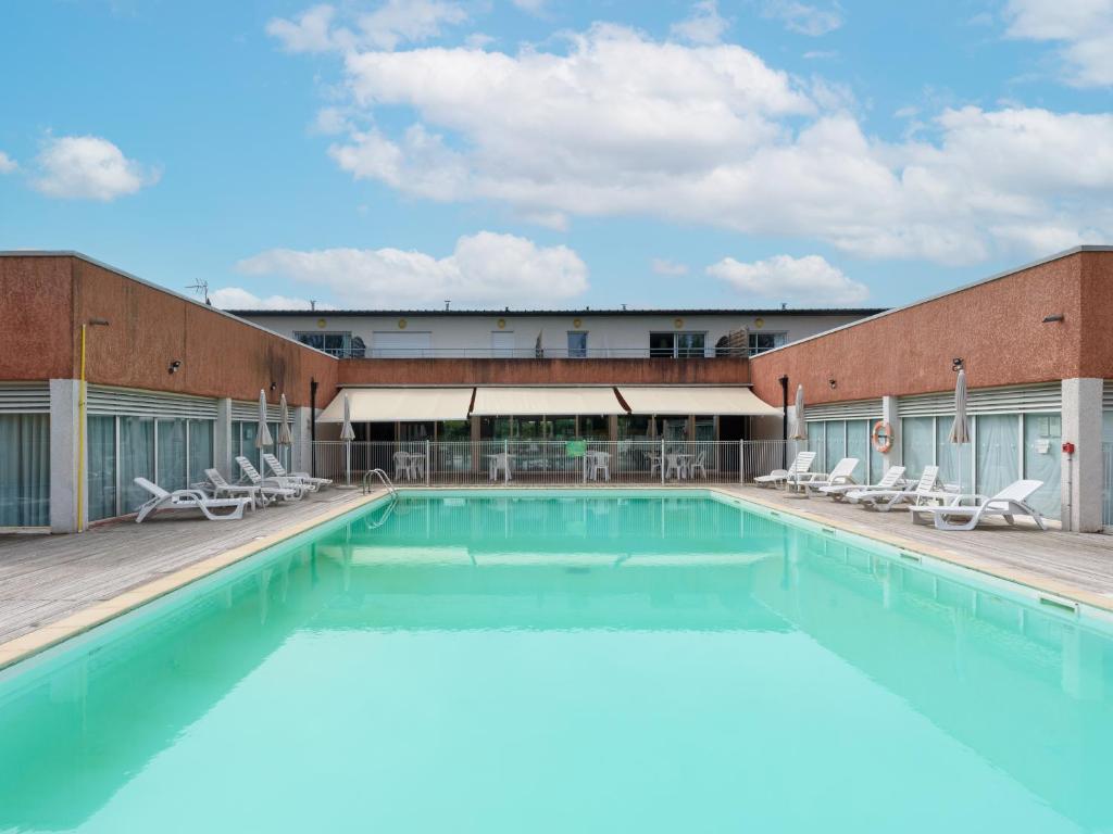 une grande piscine devant un immeuble dans l'établissement Vacancéole - Domaine du Green, à Rivières