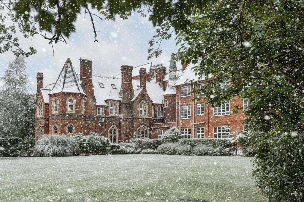 een groot bakstenen gebouw met sneeuw erop bij Best Western Abbots Barton Hotel in Canterbury