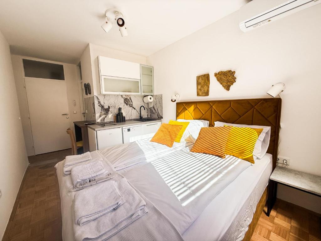 ein Schlafzimmer mit einem großen Bett mit gelben Kissen in der Unterkunft Ma Bel Apartments Sarajevo in Sarajevo