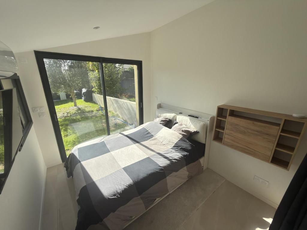 a small bedroom with a bed and a window at Studio neuf - entrée indépendante - sans cuisine in Nantes