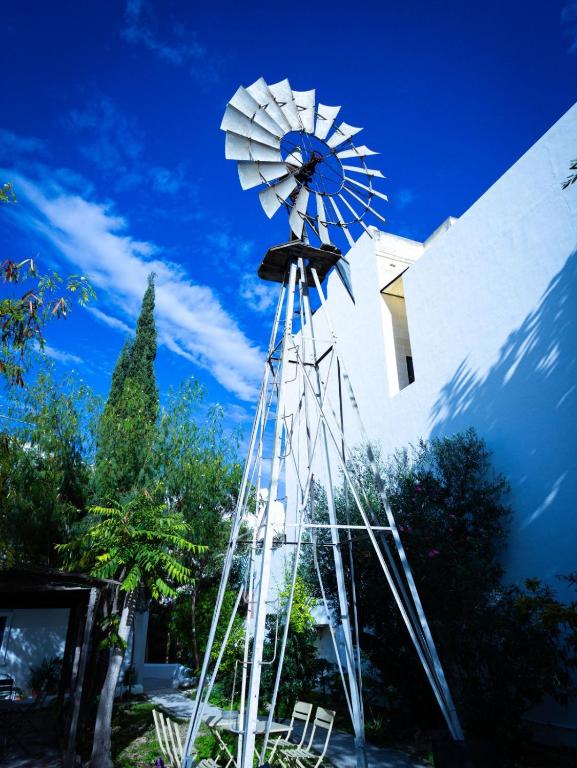 Windmill Hostel في سانت جوليانز: طاحونة هوائية أمام مبنى أبيض