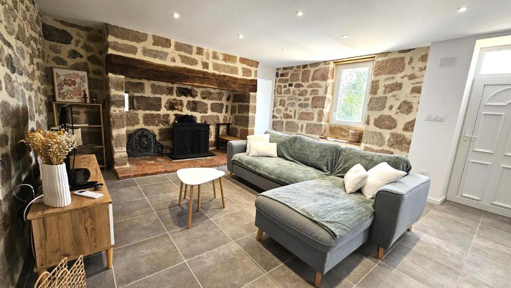 ein Wohnzimmer mit Couch und Kamin in der Unterkunft La maison bleue in Brive-la-Gaillarde