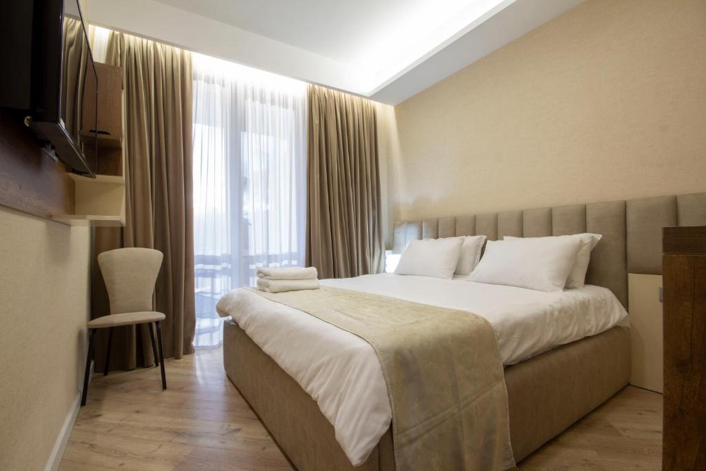 a hotel room with a bed and a television at Kinor David Glatt Kosher Hotel in Tbilisi City