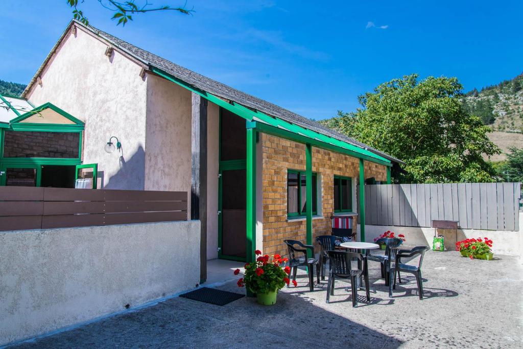 a house with a table and chairs outside of it at L'amandier à blajoux in Montbrun