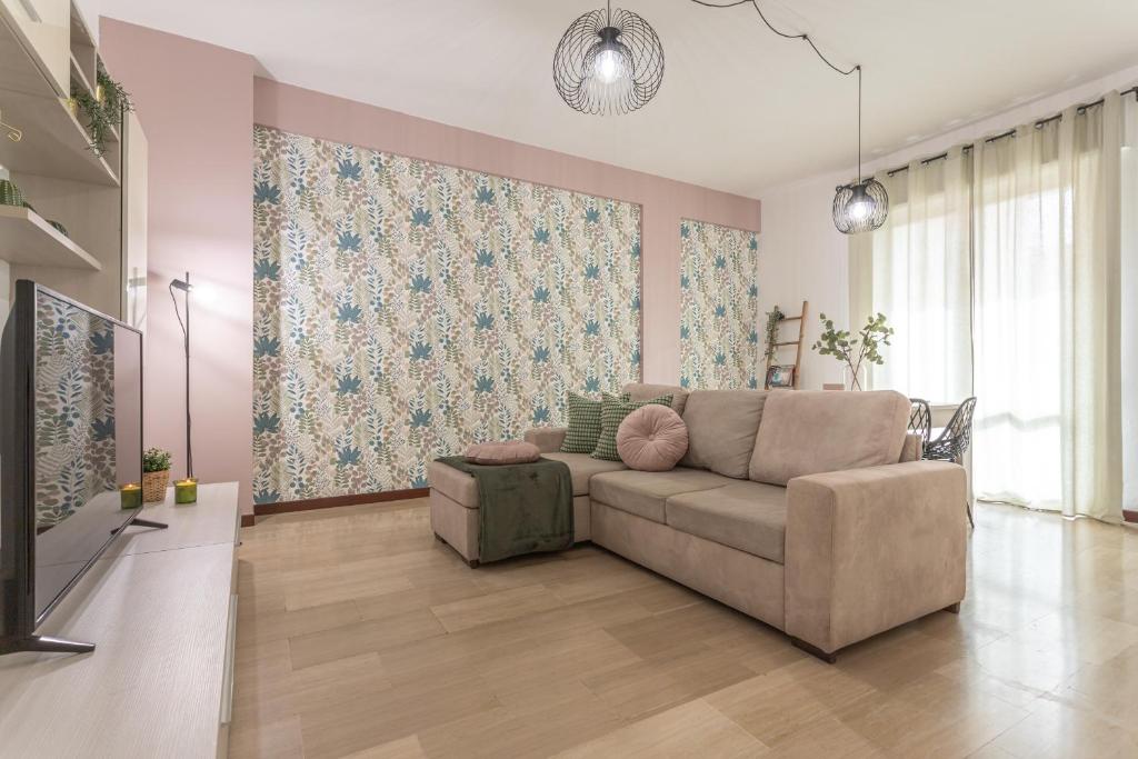 een woonkamer met een bank en een muurschildering bij Posidonia - Free Parking & Netflix - 200m to Beach in Fiumicino