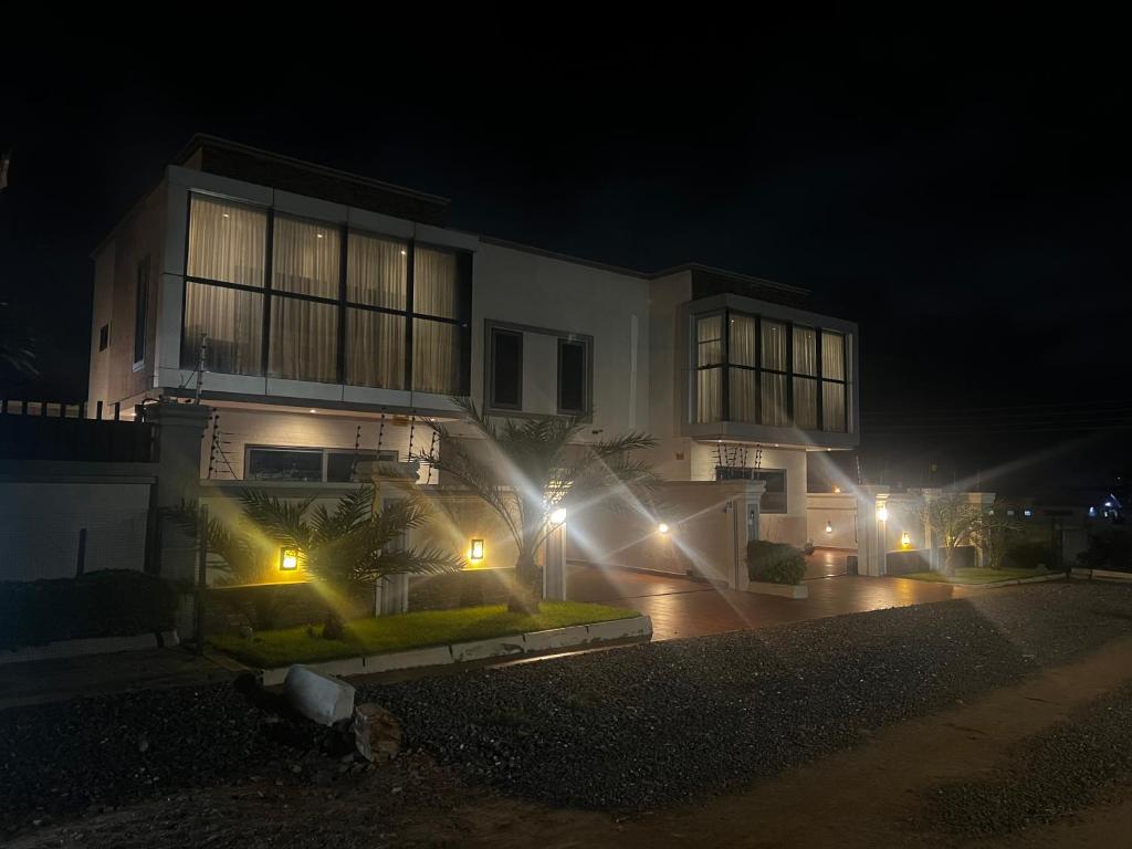 a house with lights in front of it at night at Jupiter Villa 1 and 2 in Afienya