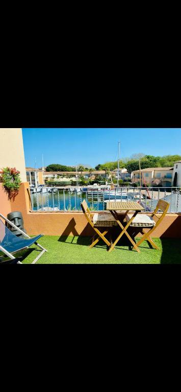 a picnic table and chairs on the grass near a boat at T2 port Cogolin golfe de Saint-Tropez vue mer in Cogolin