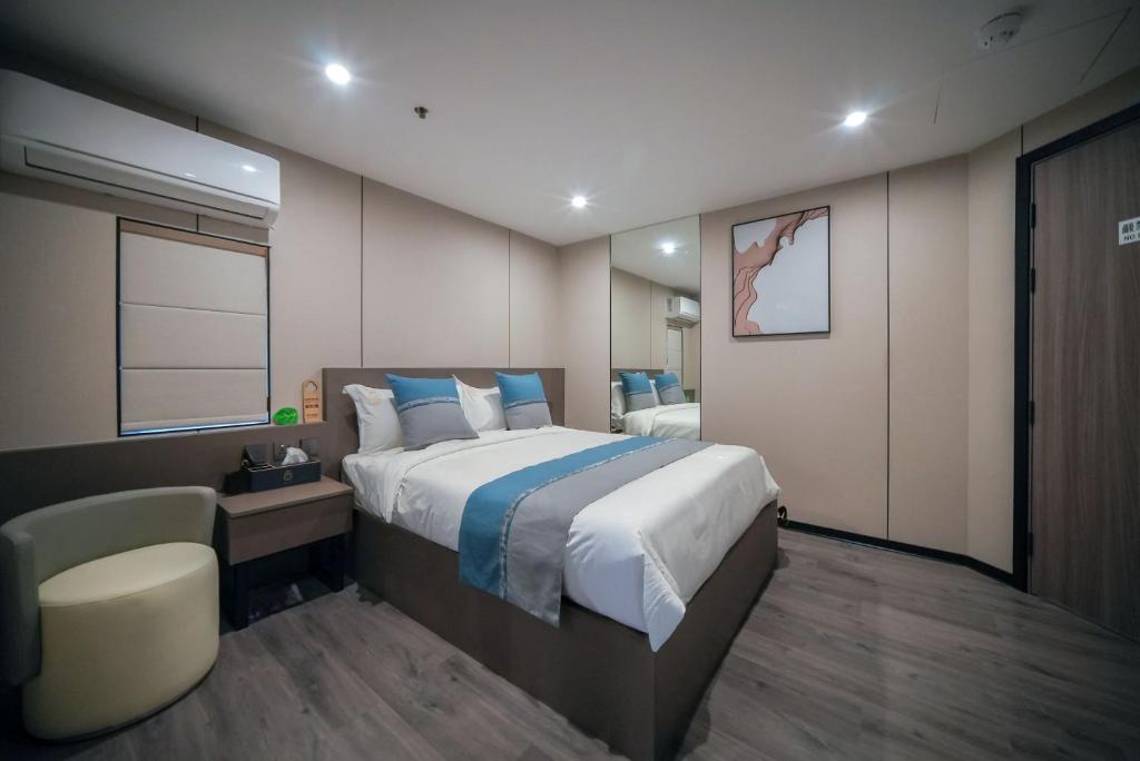 a bedroom with a large bed and a chair at Ha Fa Villa in Hong Kong