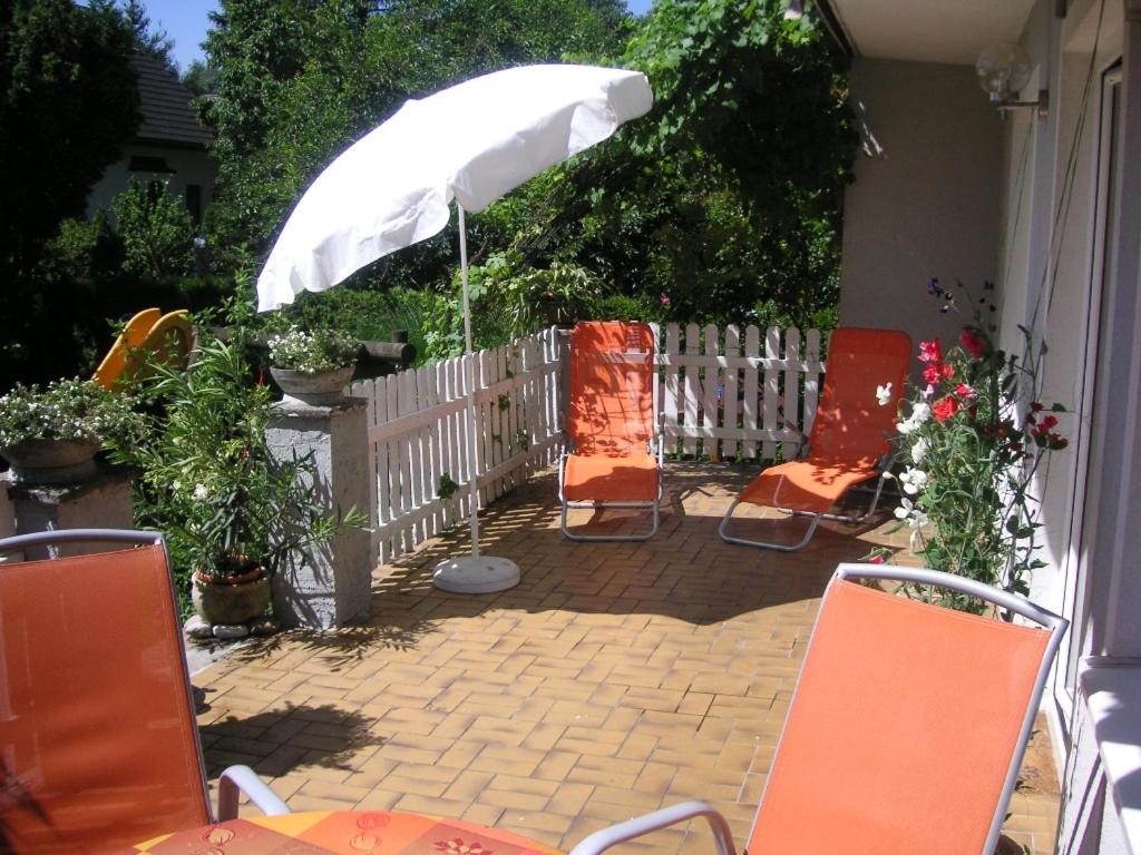 um pátio com cadeiras laranja e um guarda-sol em Haus Hillinger em Salzburgo