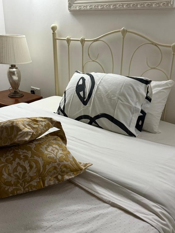a bed with white sheets and pillows on it at Valletta apartment in Valletta