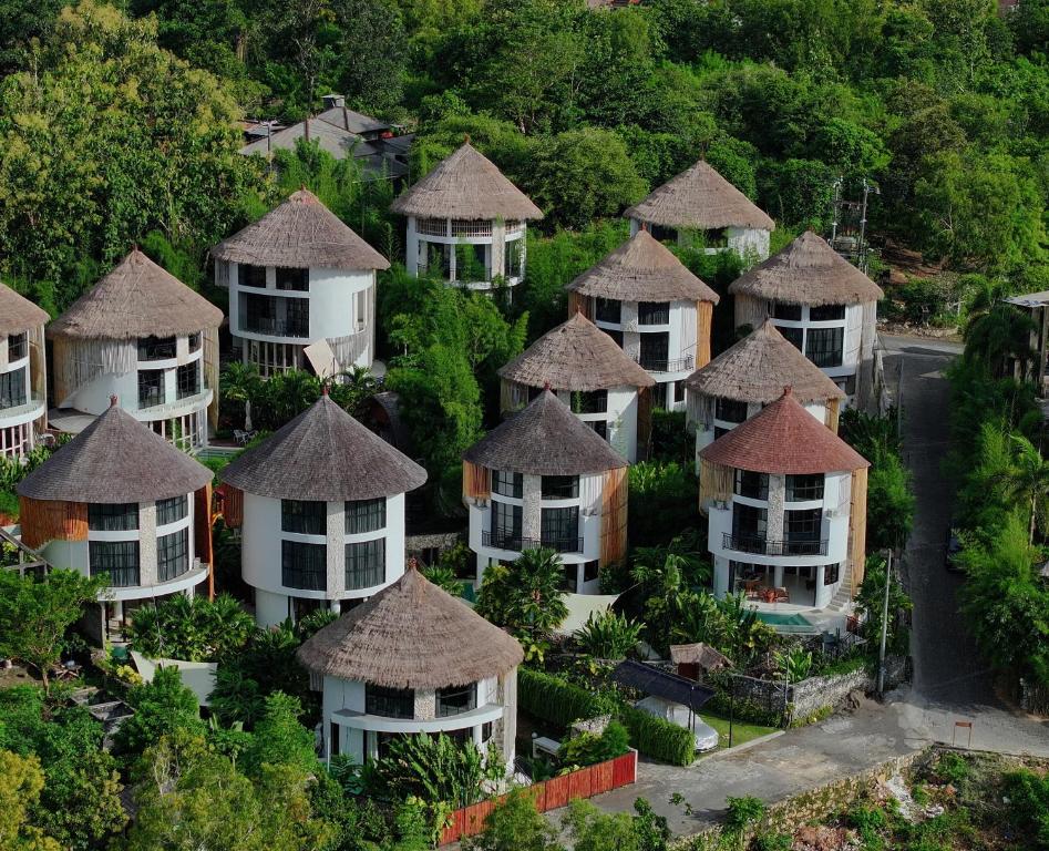an aerial view of a bunch of houses with thatched roofs at Hillstone Luxury Village in Uluwatu