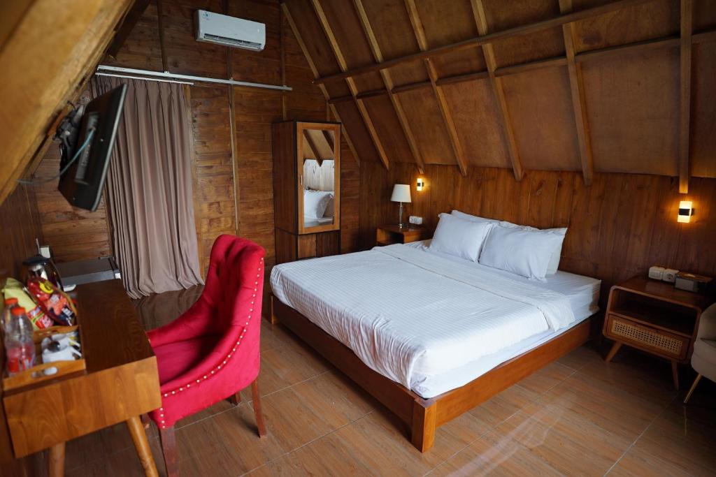 a bedroom with a bed and a desk and a chair at Vinn Villa, Coffee & Resto in Bugel