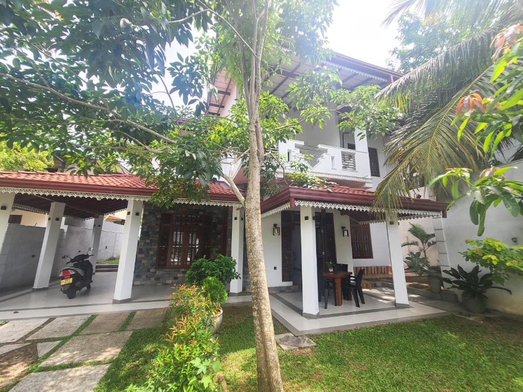 a house with a motorcycle parked in front of it at AfterFly in Ahangama