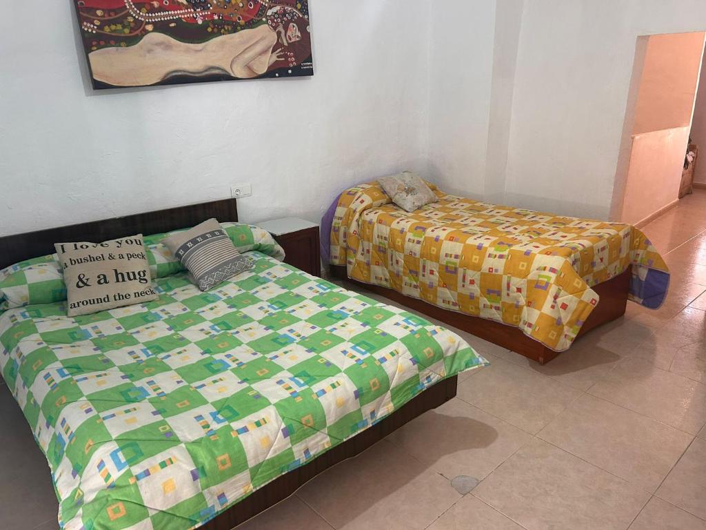 a bedroom with two beds and a pillow on it at La Casa los Trancos, a 15 minutos de Cazorla in Peal de Becerro