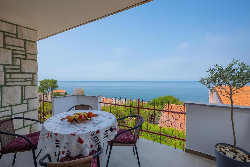 a table on a balcony with a view of the ocean at Apartment Crveni - a three bedroom apartment with a stunning sea view in Umag