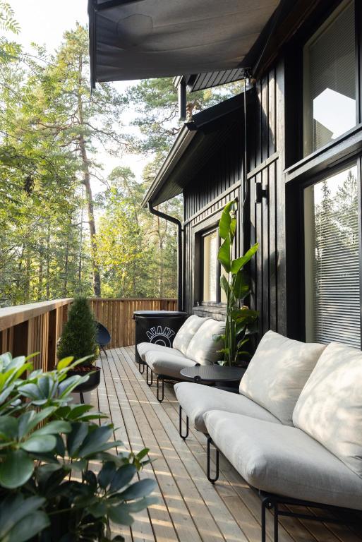 a row of couches on a porch with plants at Villa MiaEmilia B in Espoo