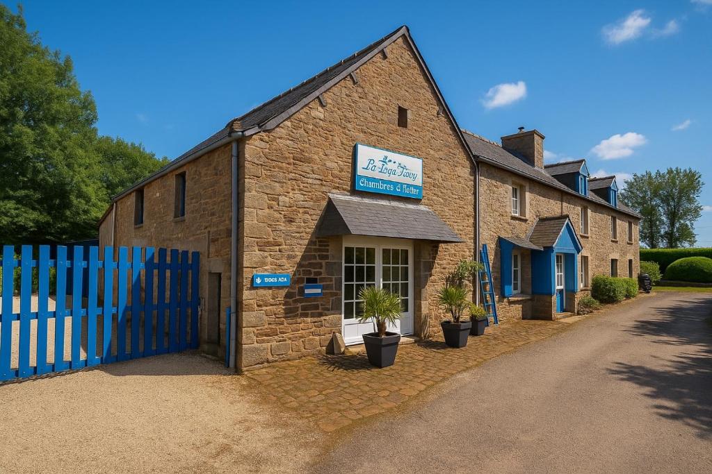 an old brick building with a blue fence at Chambres d'hôtes la Bégaudière in Dol-de-Bretagne
