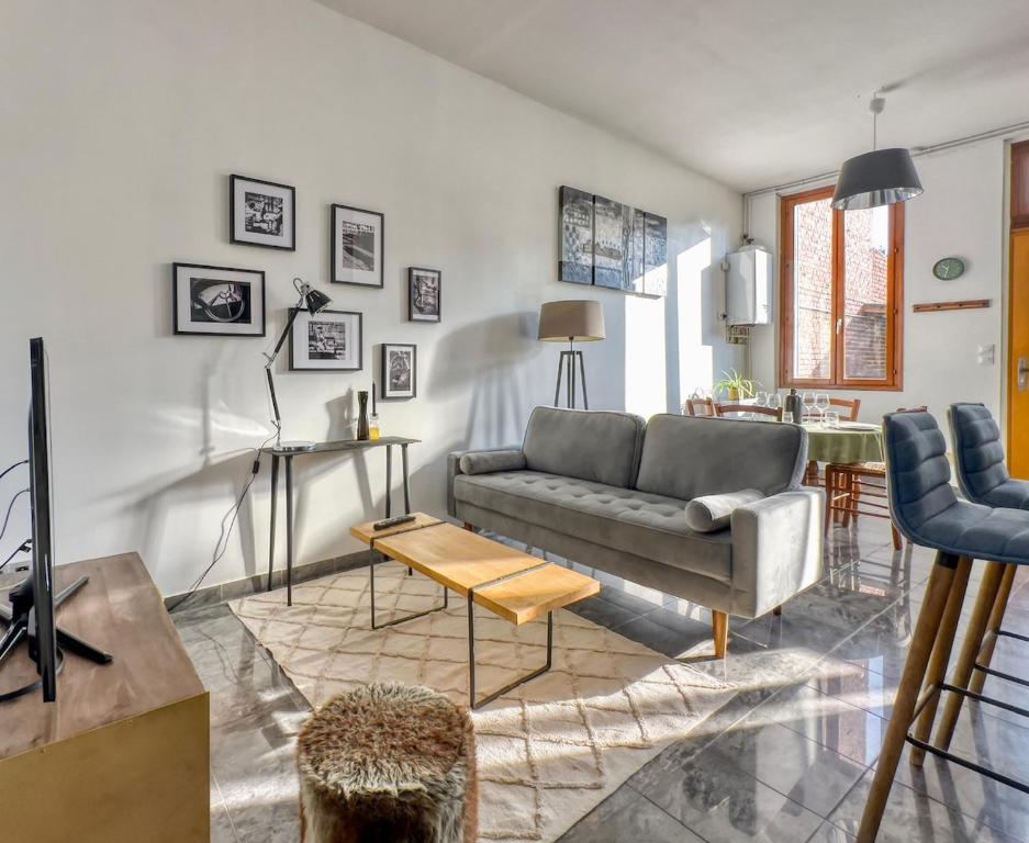 a living room with a couch and a table at La Saint Joseph in Compiègne