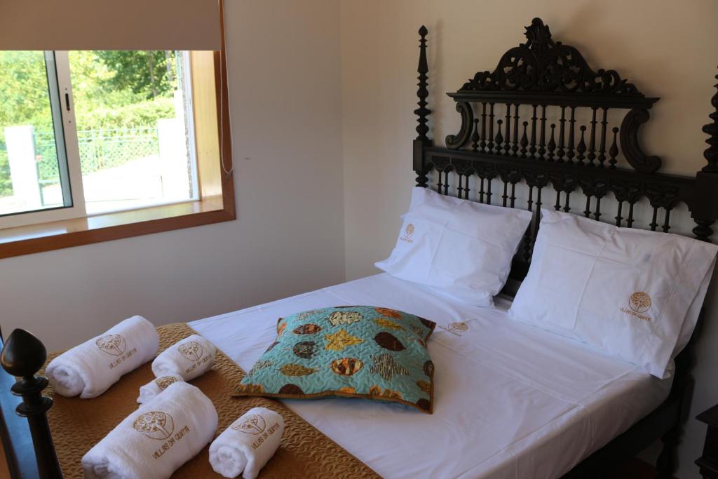 Un dormitorio con una cama con sábanas y almohadas blancas. en Villas da Quintã, en Cabeceiras de Basto