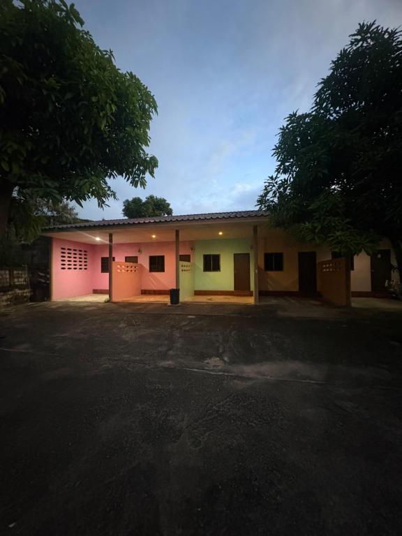 a building with a parking lot in front of it at อู๊ดดี้บริการห้องพัก in Nong Prue