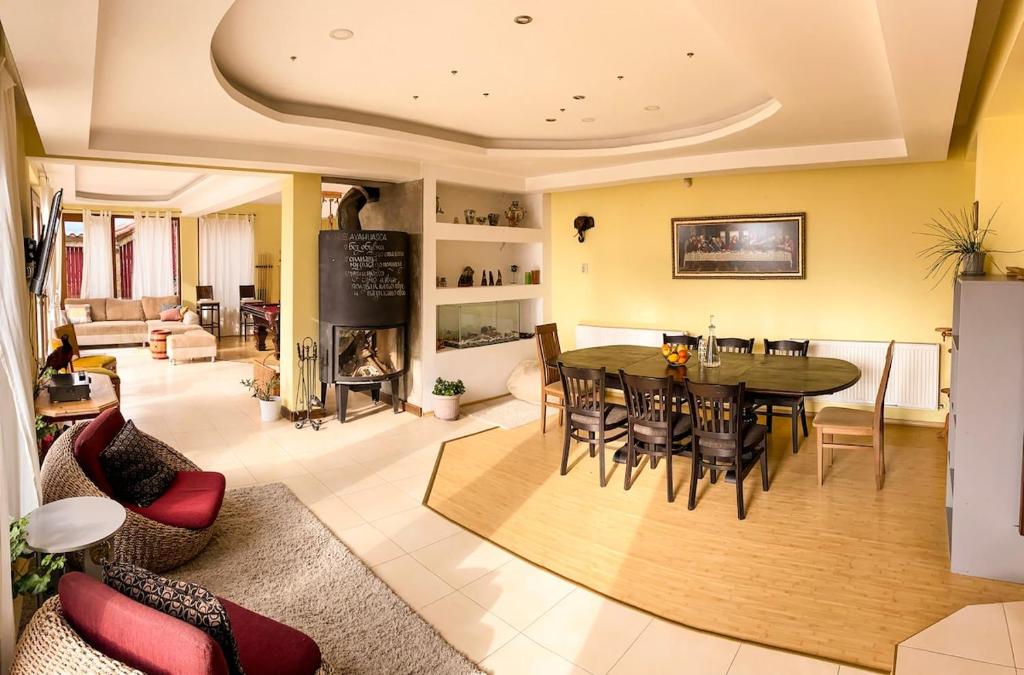 a dining room and living room with a table and chairs at Villa Madera - Spacious House with Swimming Pool, Sauna and Pool Table in Saparewo