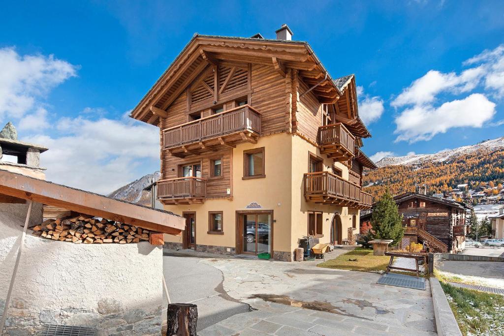 Un gran edificio con balcones de madera en una montaña. en Livigno Wooden House, en Livigno