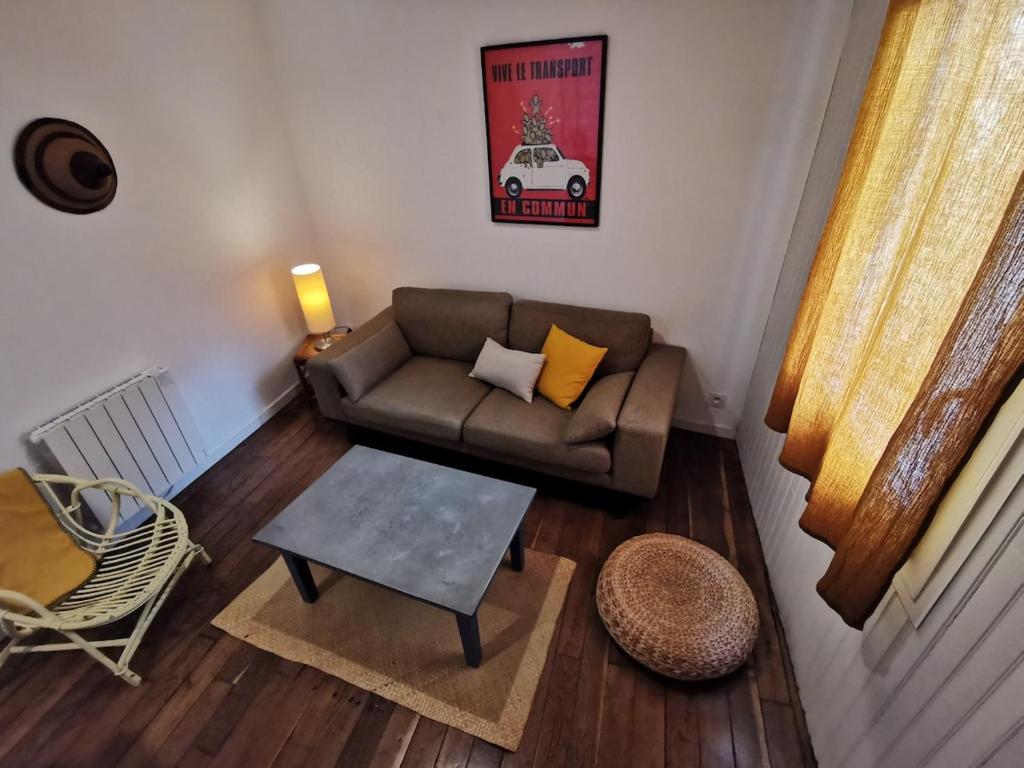 ein Wohnzimmer mit Sofa und Tisch in der Unterkunft Au Ptit Gauguin in Pont-Aven