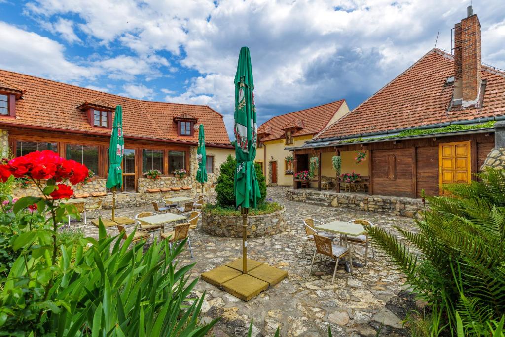 Un patio con mesas y sombrillas frente a un edificio. en Hotel BELLA, en Praga