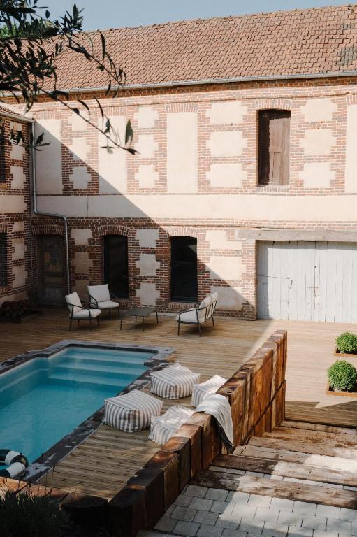 a patio with a swimming pool and a building at Maison Eudoise, piscine et spa in Eu