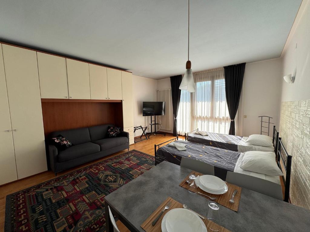 OTB Italia 1 - Luminoso appartamento tra Venezia e Treviso con Terrazza e Posto auto Coperto في بريغانزيول: غرفة معيشة مع أريكة وطاولة