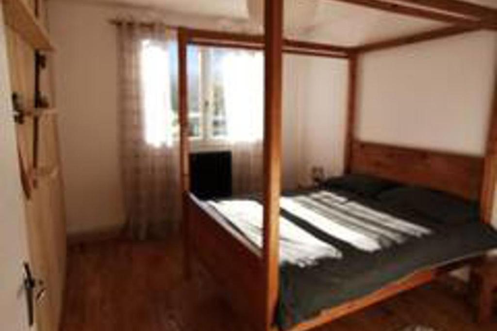 a bedroom with a four poster bed and a window at 3 Bed - Sleeps 8 - Mountain View - Balcony - Pets in Saint-Béat