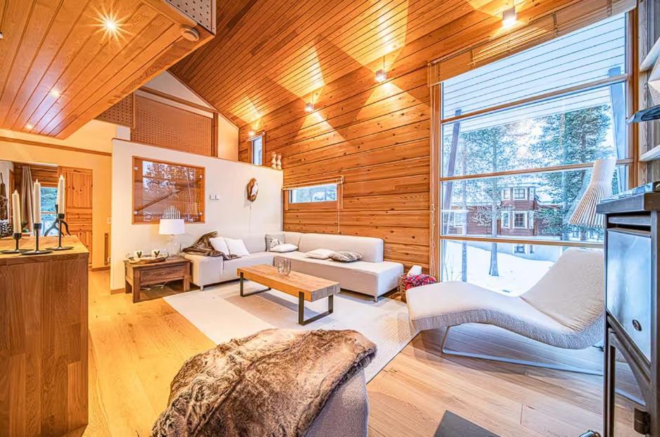 a living room filled with furniture and a large window at Beautiful cottage in Lapland ! in Kittilä