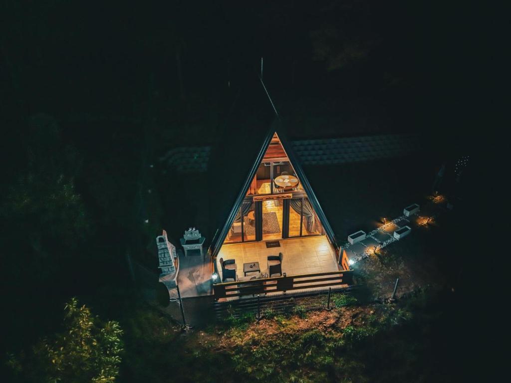 a small house with a lit up roof at night at Oaza mira HaDaNa in Tihovići