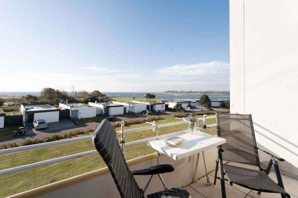 a balcony with a table and chairs and a view at Strandhaferweg 7 Möwenoase in Burgtiefe auf Fehmarn 