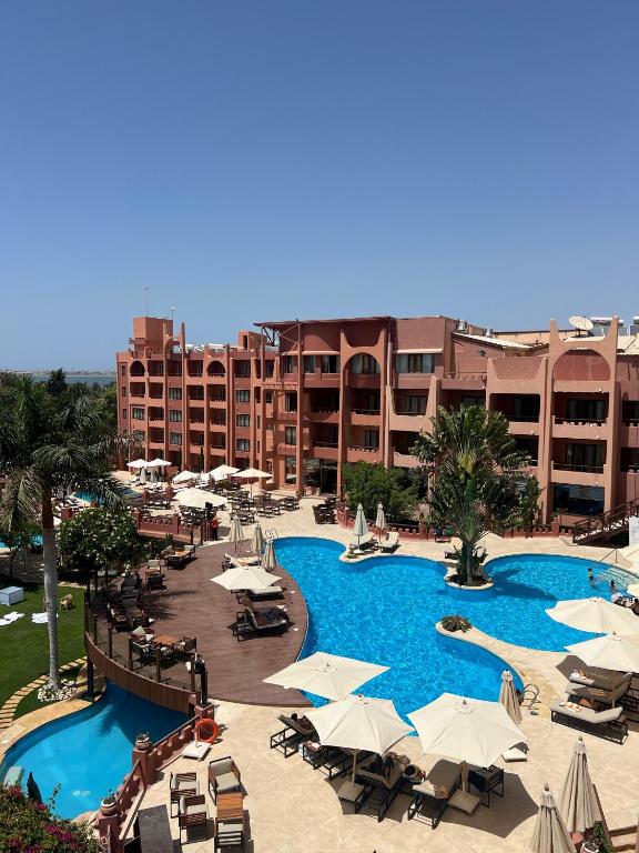 a large swimming pool with umbrellas and chairs in a resort at Africana Hotel & Spa in Alexandria
