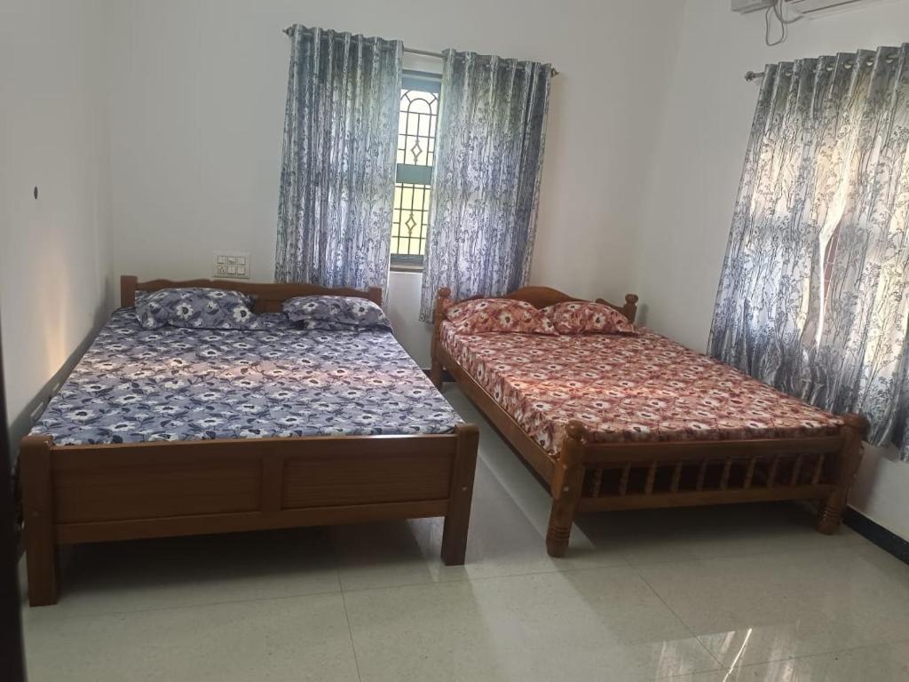 twee bedden in een kamer met ramen bij White House Home Stay! in Kaup