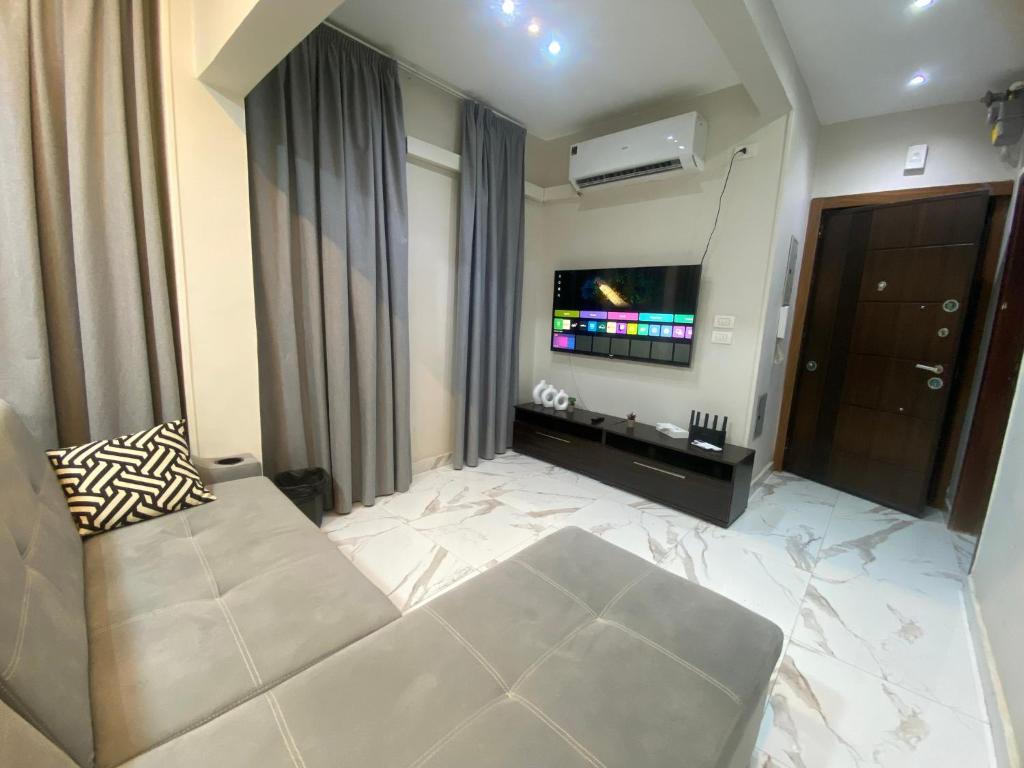 a living room with a couch and a flat screen tv at Golden Ibis Memphis in Cairo