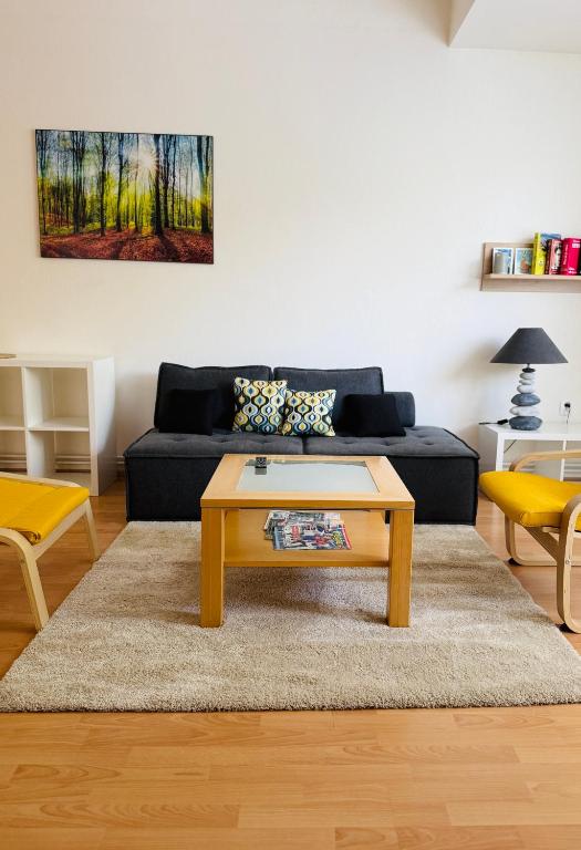 a living room with a couch and a coffee table at Srdce Mesta 1 - zážitkový apartmán Na Pešej Zóne s balkónom a terasou in Gerlachov