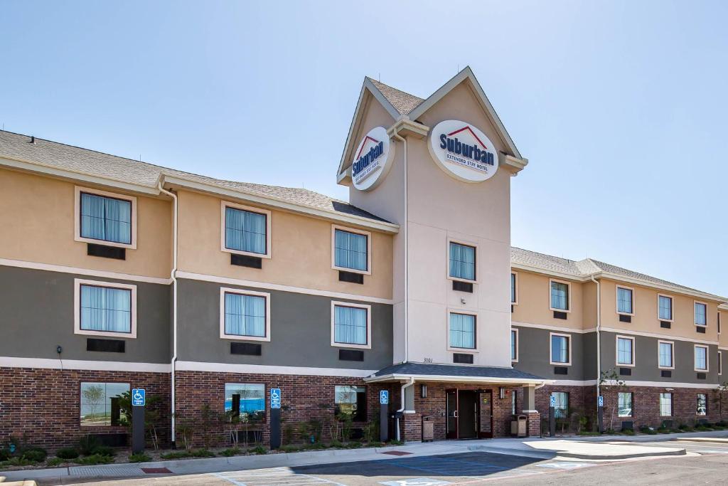 a hotel with a clock on the side of it at Suburban Studios Midland I-20 in Midland